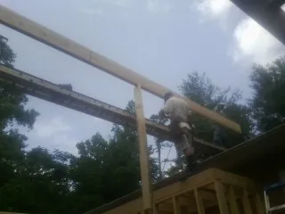 Carpenter setting a ridge beam over a new addition frame — Ice Dam Removal by Roofing Brothers in Scurry