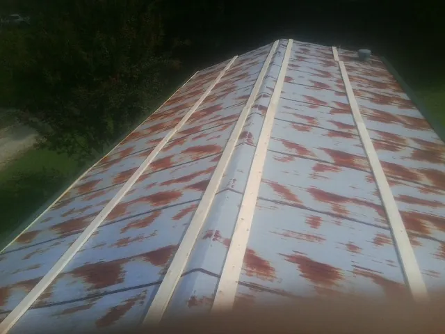 Rusted metal roof panels with new wood purlins before replacement — Storm Damage Roof Repair in Scurry by Roofing Brothers