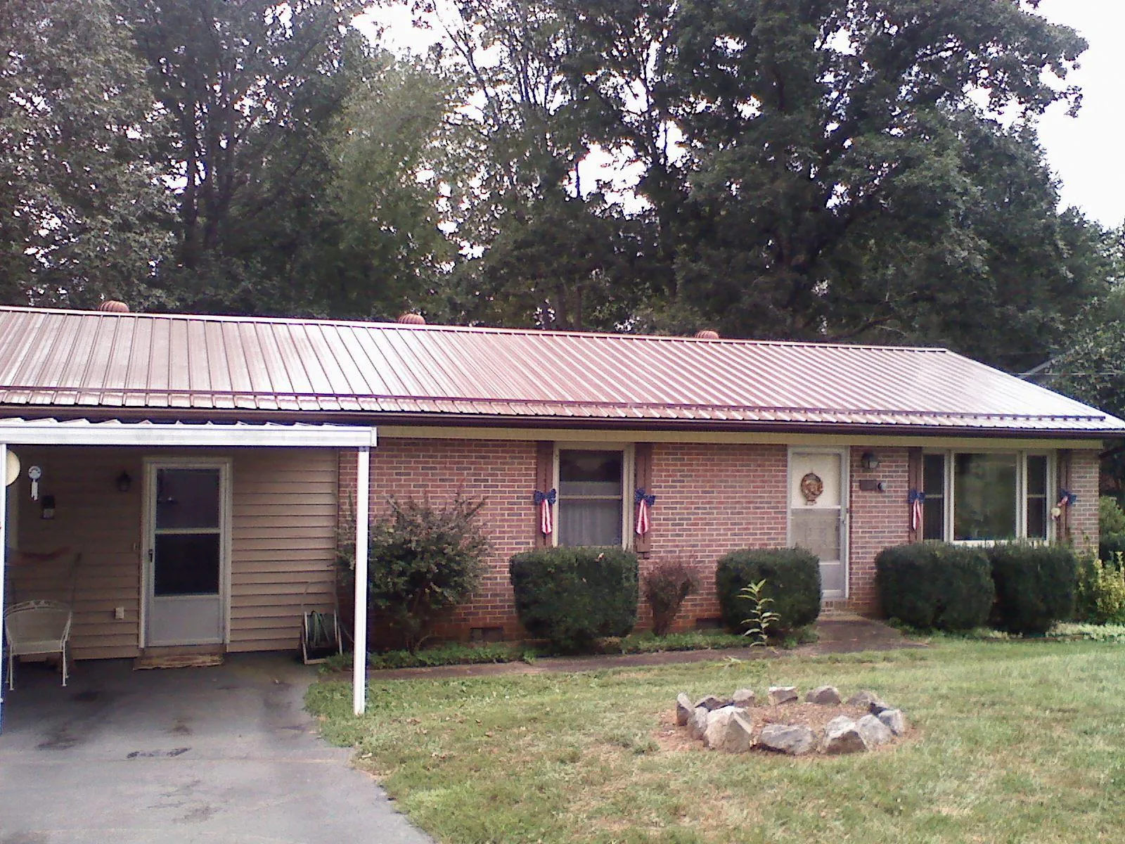 Bronze metal roof and carport on a brick ranch home — Roof Repair work by our crew in Scurry